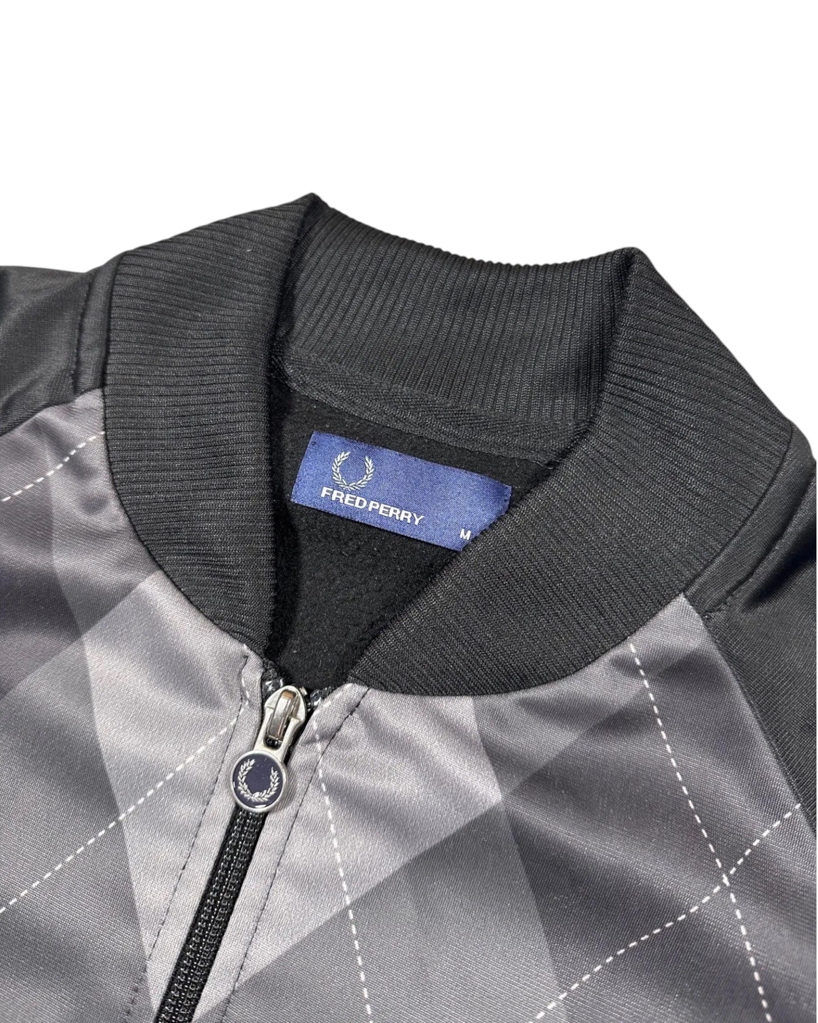 Casual Circuit. Fred Perry track jacket with a grey and black argyle pattern, polyester, full-length zip and ribbed cuffs.