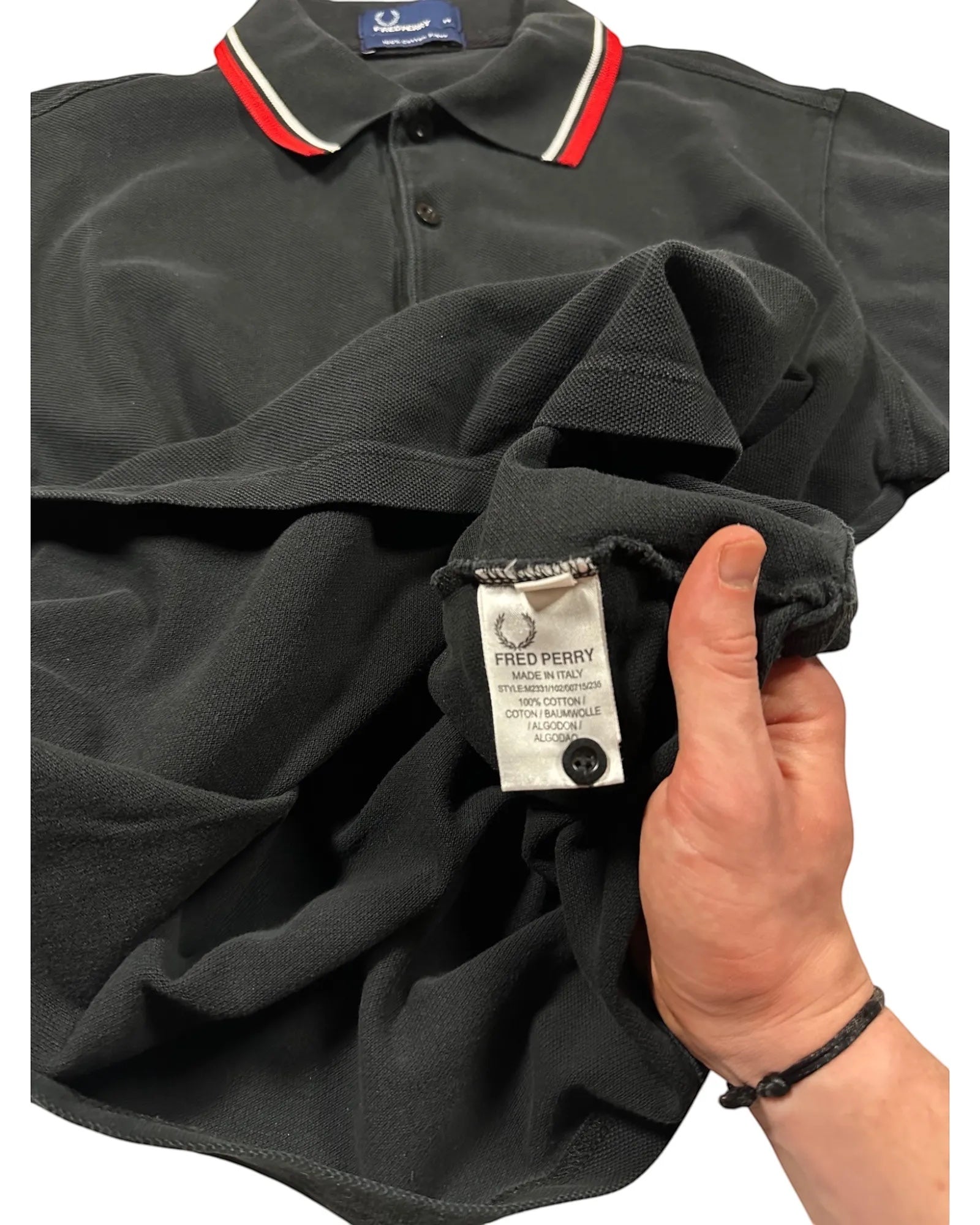 Casual Circuit. Black men's cotton polo shirt with red and white collar stripes and Fred Perry logo.