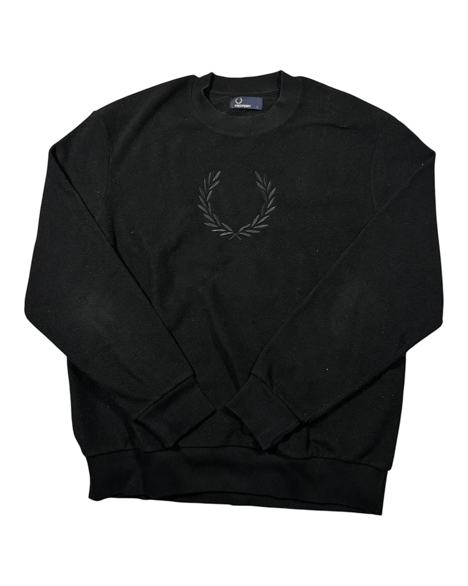 Casual Circuit. Black Fred Perry jumper with a laurel wreath logo on the chest, crew neck and ribbed cuffs.